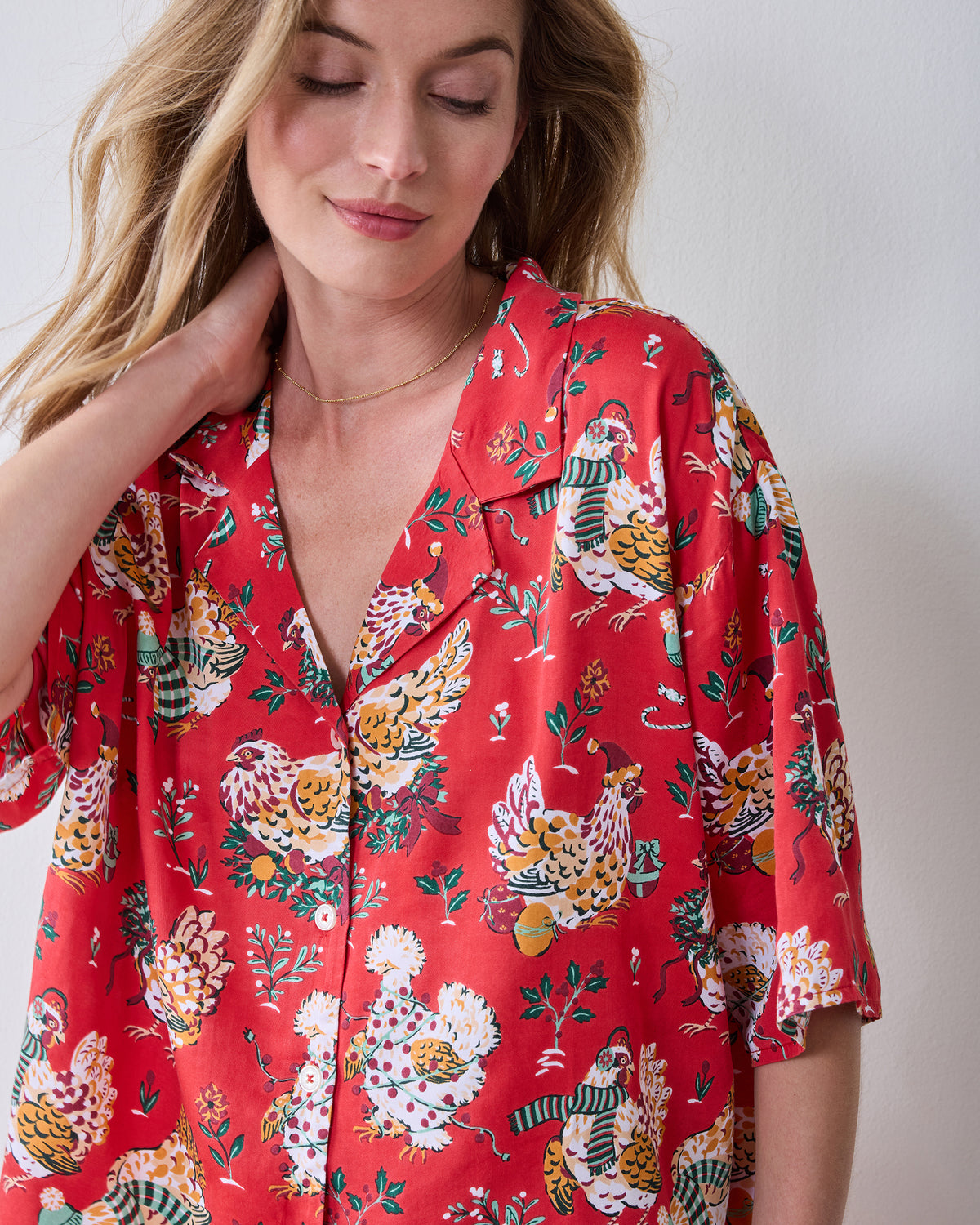 Model wearing a red chicken-print pajama top with a notched collar, button front, and three-quarter sleeves.
