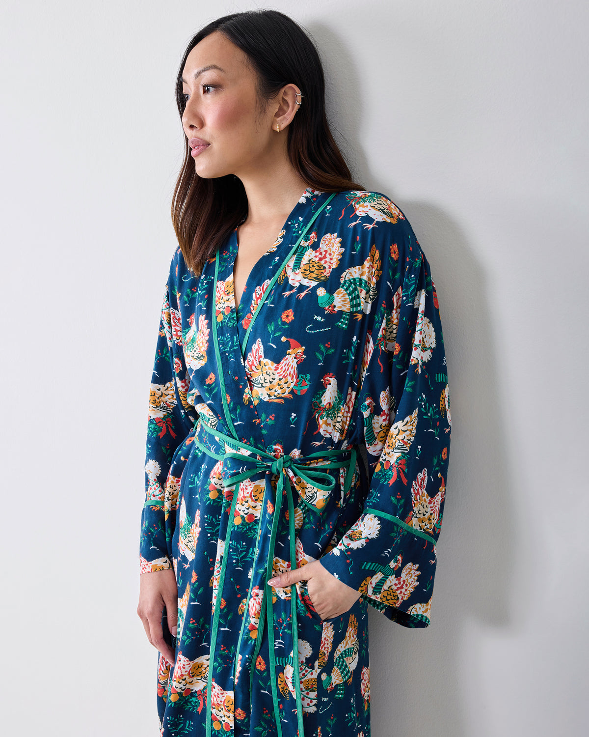 Model wearing a navy chicken-print robe with contrasting trim, a matching belt, and side pockets.