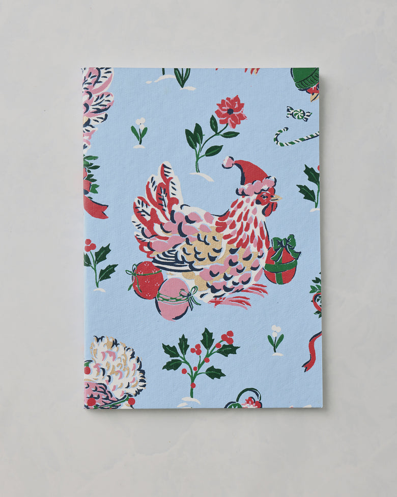 Light blue Holiday Icons notebook cover with a decorated chicken wearing a Santa hat, ornaments, flowers, and holly motifs.