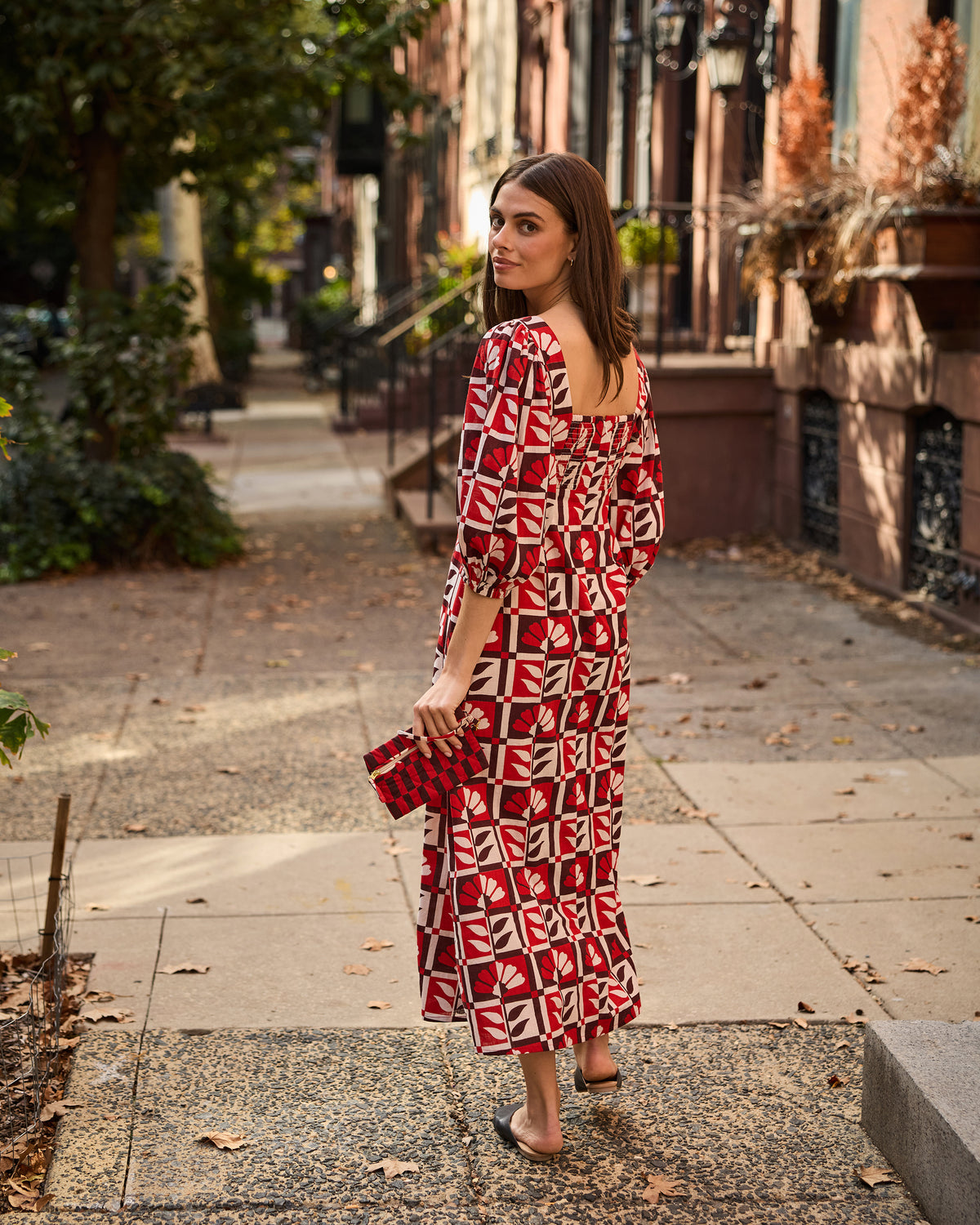 Back view of the Constance dress in a red-and-white floral geometric print, showing the square back neckline and gathered waist.