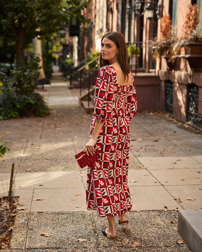 Back view of the Constance dress in a red-and-white floral geometric print, showing the square back neckline and gathered waist.