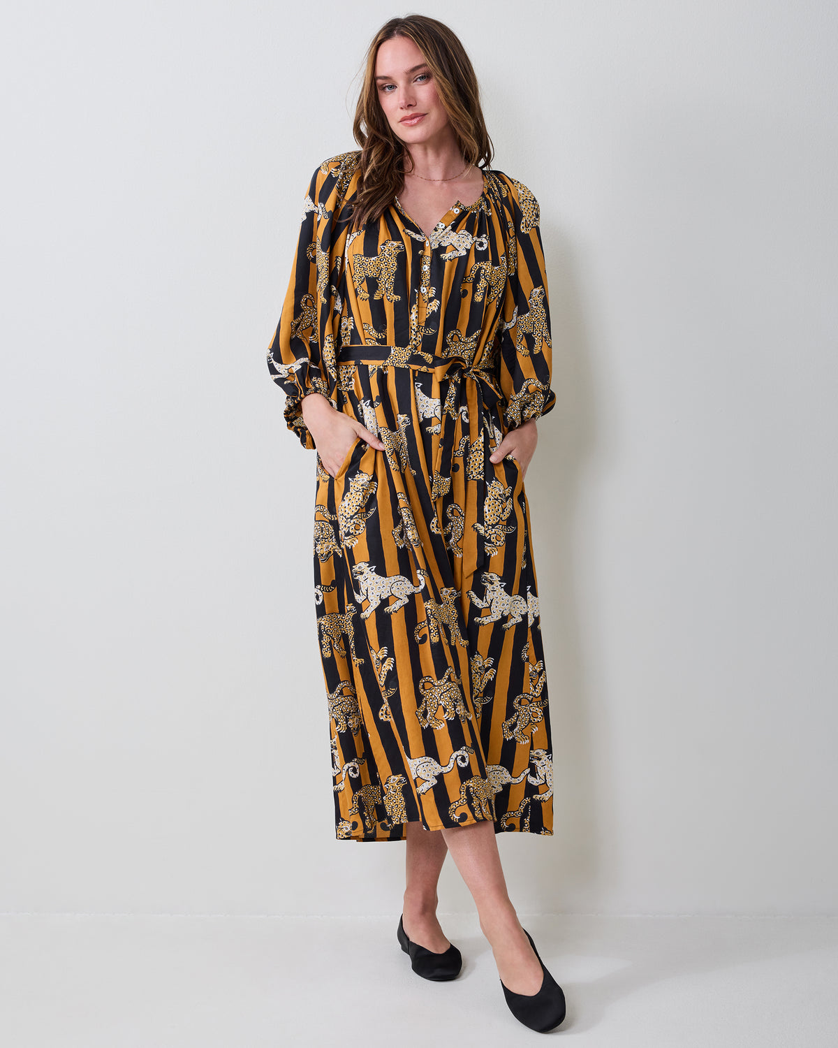 Full front view of the Leopard Stripes Felicity dress with long sleeves, a V-neckline, waist tie, pockets, and midi-length hem.