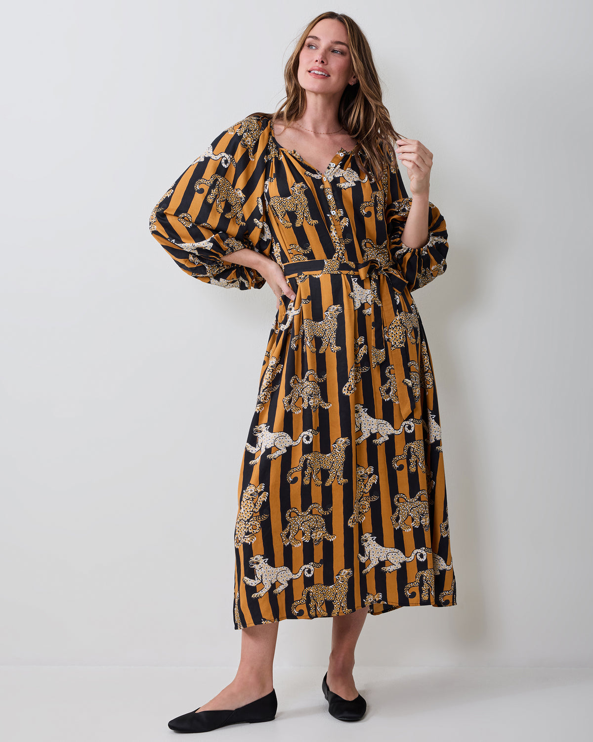 Full-length view of a belted leopard-print Felicity dress with long billowy sleeves and butterscotch-and-black stripes.
