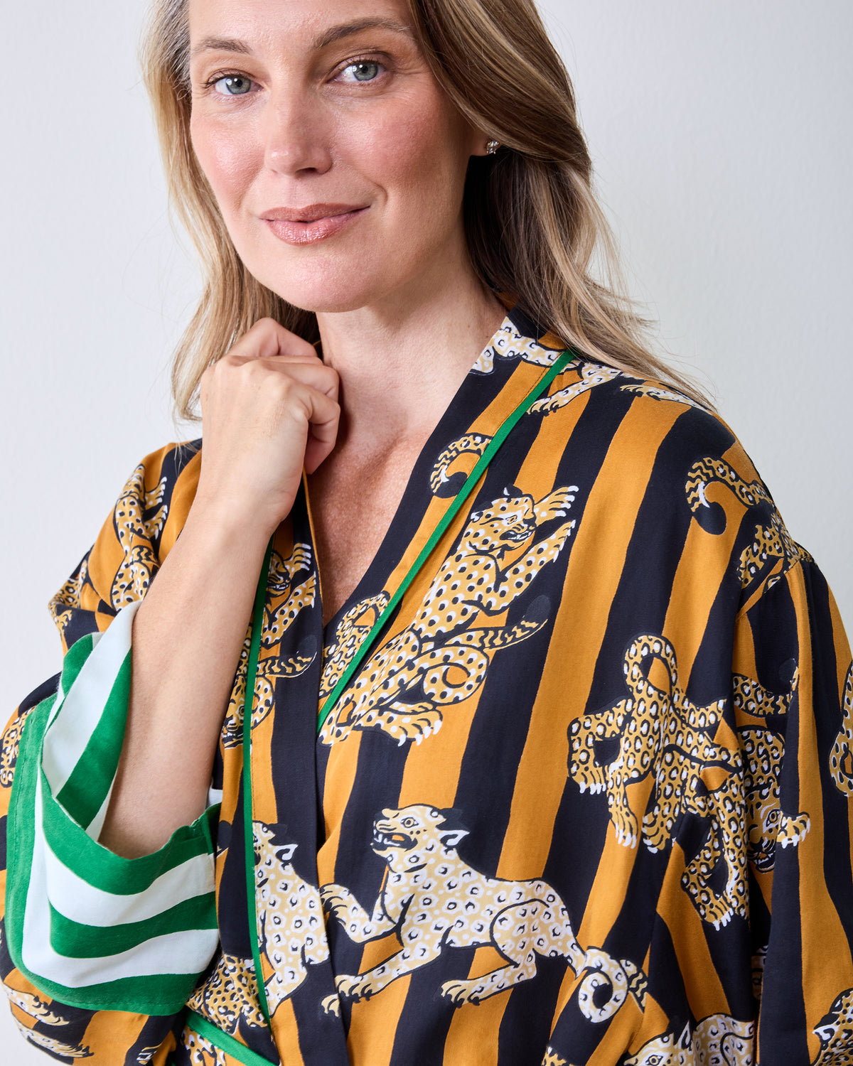 Close view of the butterscotch Leopard Stripes robe showing the striped leopard print, green trim, and wide striped sleeve cuff.