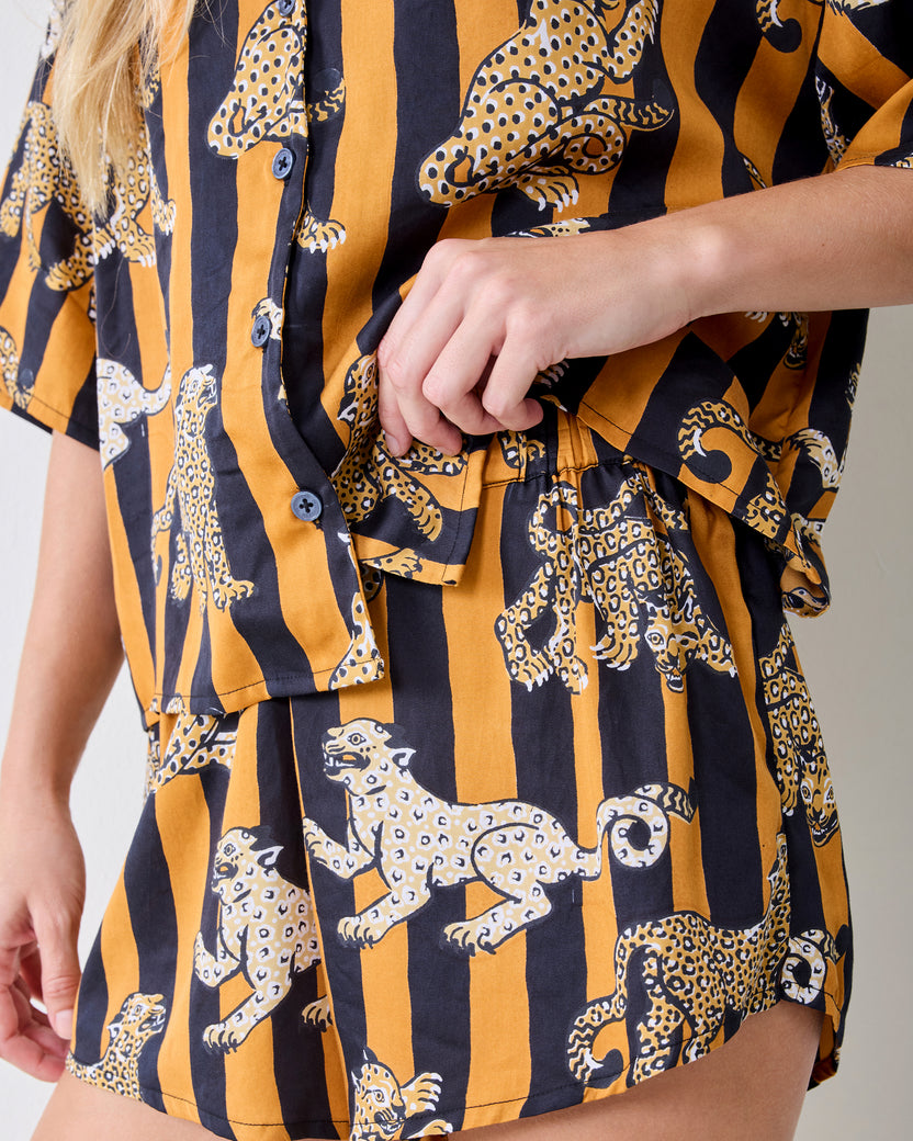 Close-up of the striped leopard-print pajama set showing the button-front top, waist tie, and shorts.