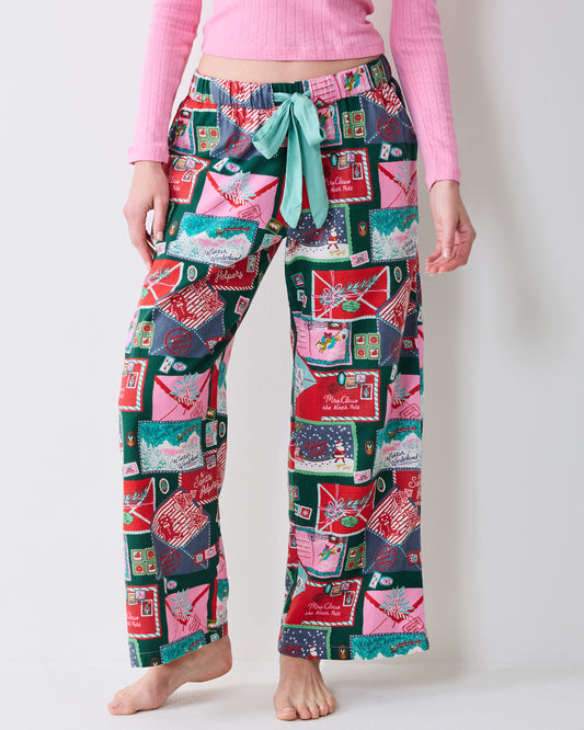 Close front view of Letters to Santa flannel pajama pants showing the elastic waistband, satin tie, and holiday letter print.
