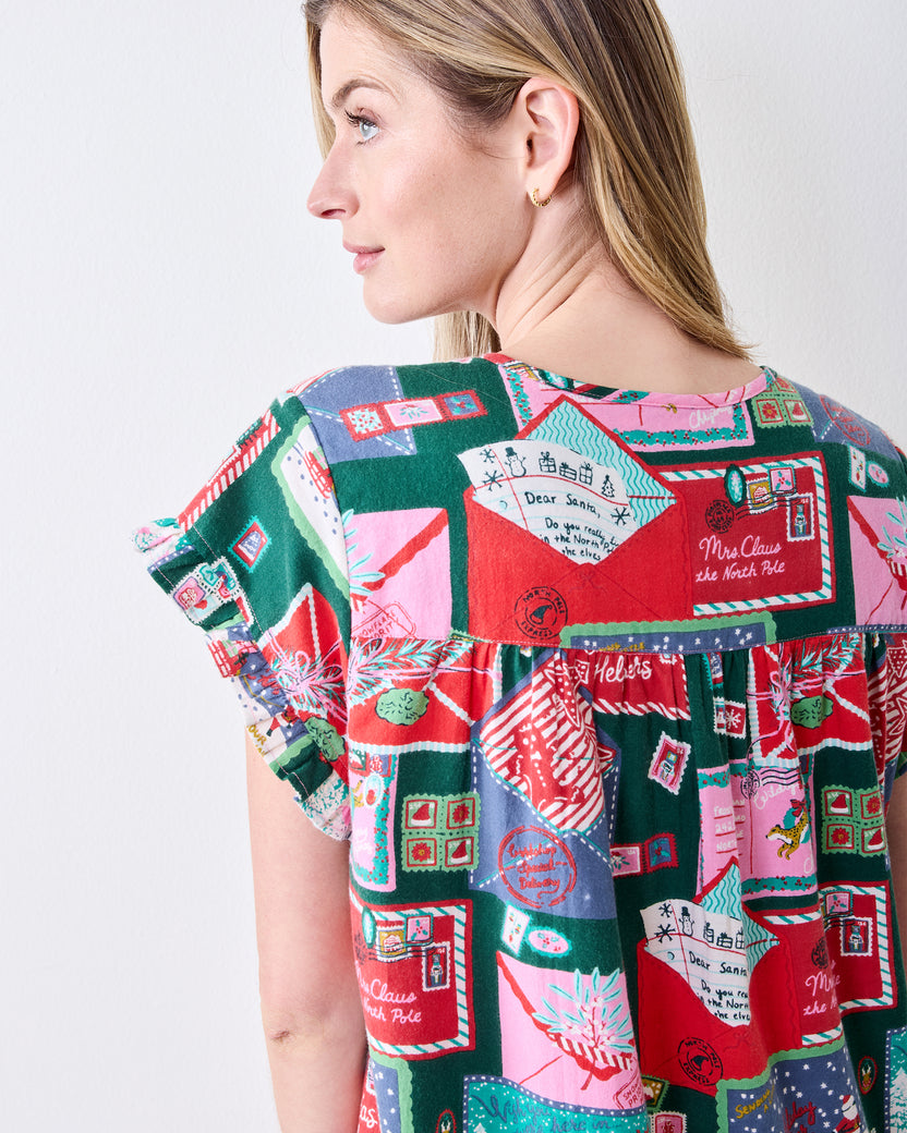 Back view close-up of the Letters to Santa flannel nightgown showing the gathered yoke, short sleeve, and holiday card print.