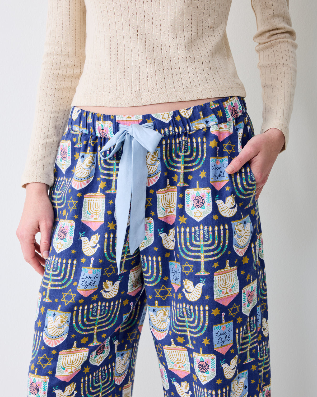 Close view of the Hanukkah Blue Love & Light pants showing the patterned wide legs, elastic waistband, light blue drawstring, and side pockets.