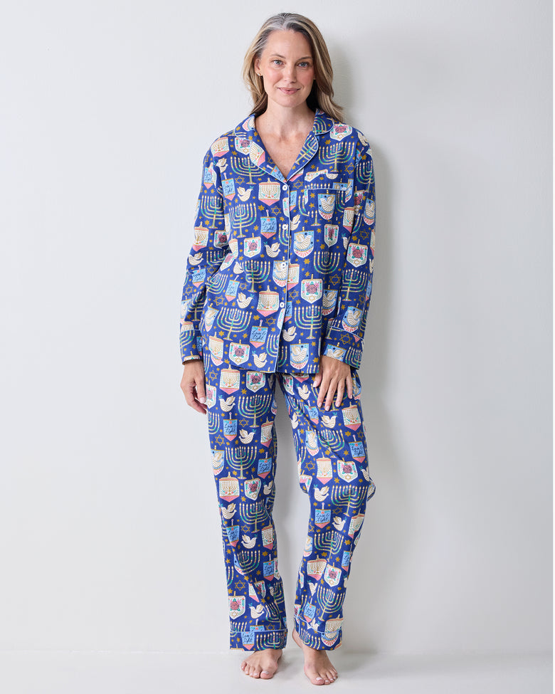 Person wearing a blue long-sleeve pajama set with menorah, dreidel, and Star of David prints