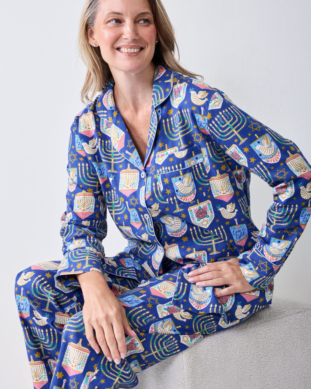 Seated model wearing the Love & Light long flannel pajama set with a button-down top and matching pants.
