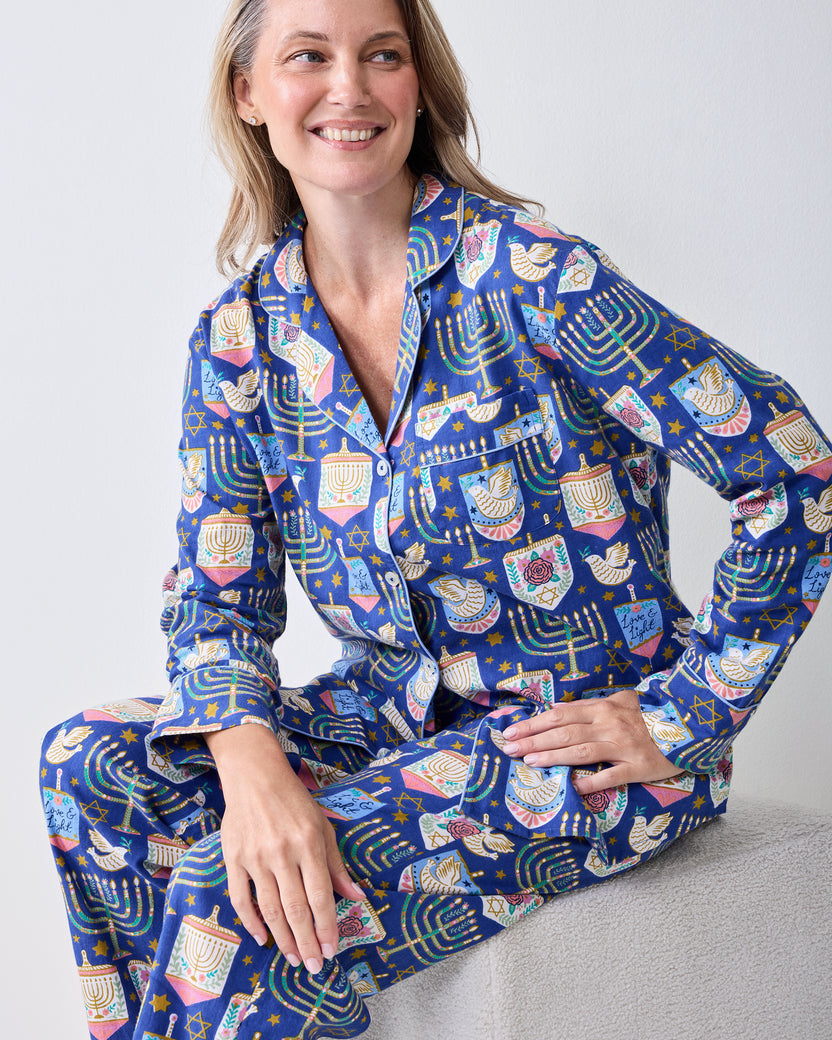 Seated model wearing the Love & Light long flannel pajama set with a button-down top and matching pants.