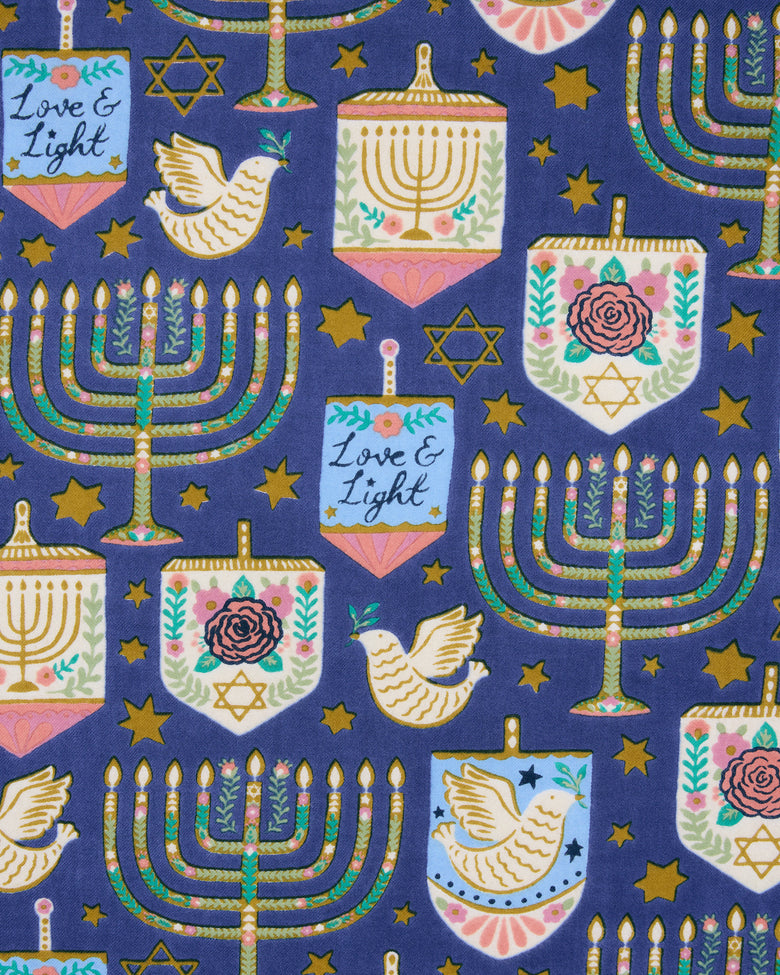 Hanukkah-themed blue tea towel print with menorahs, dreidels, stars, doves, and menorah-shaped ornaments.