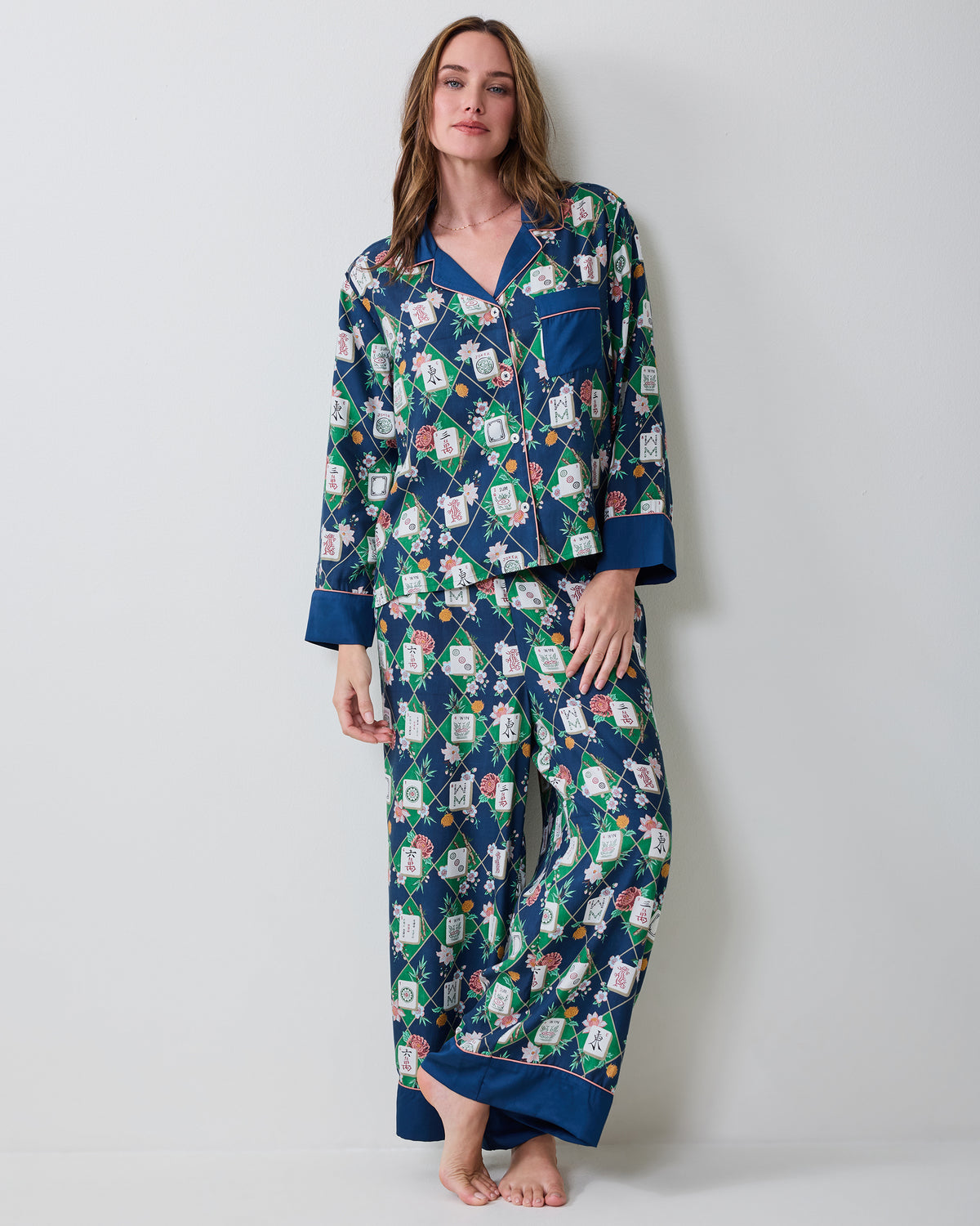 Full front view of a person wearing the Mahj Garden Wintergreen Eco Satin Soho pajama set with a patterned button-front top and matching wide-leg pants.