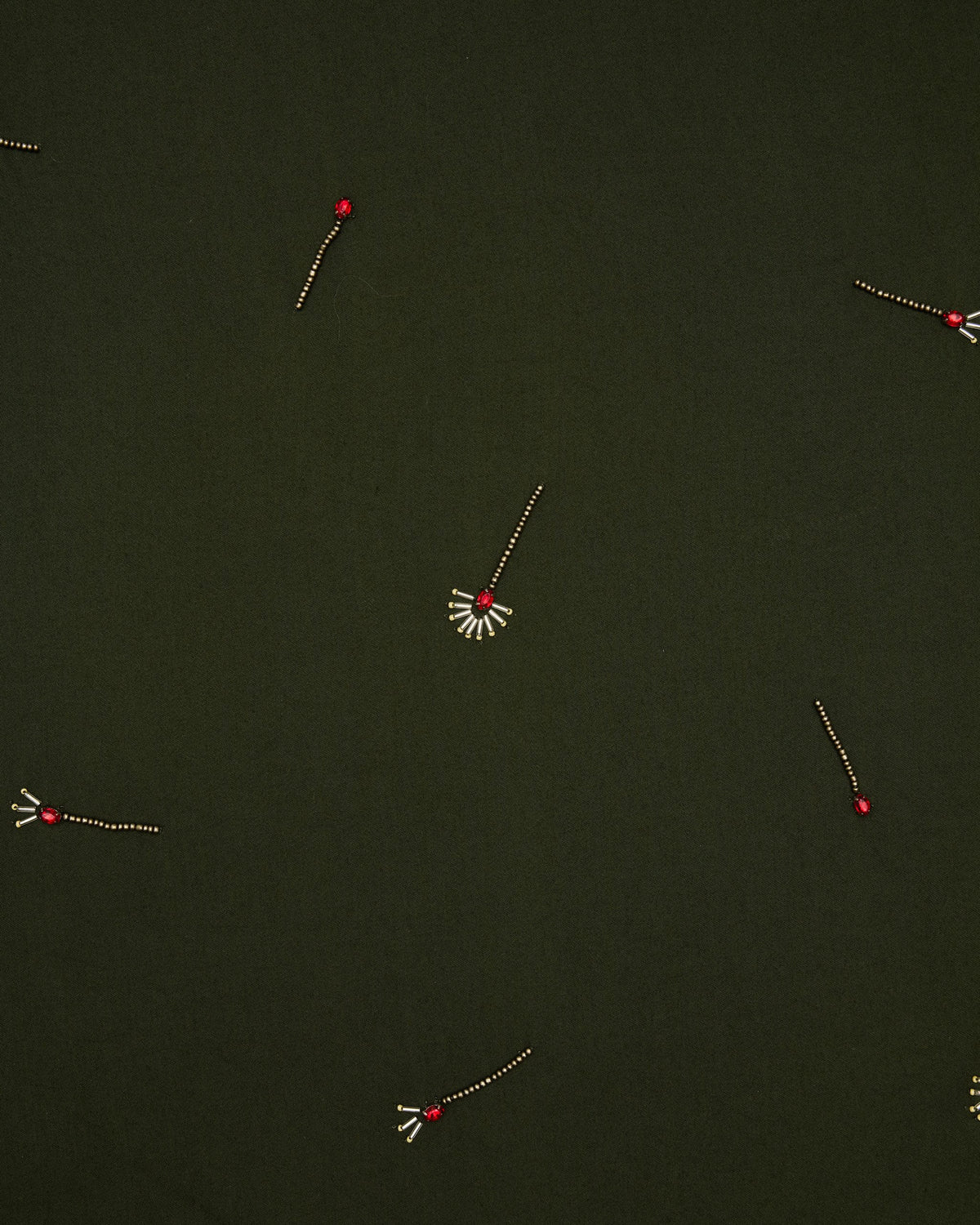 Close-up of the olive fabric featuring scattered embroidered red-and-gold motifs.