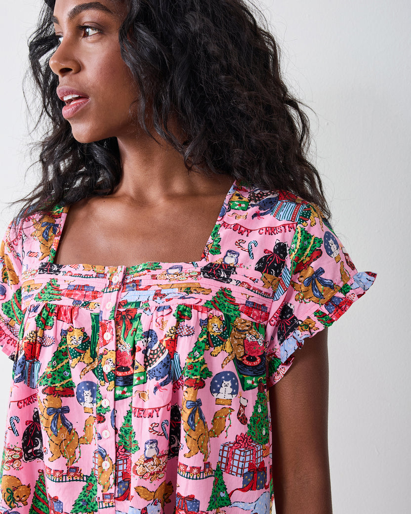Person wearing the candy-pink Meowy Christmas pintuck nightgown with short sleeves, buttons, a ruffled neckline, and a festive cat print.