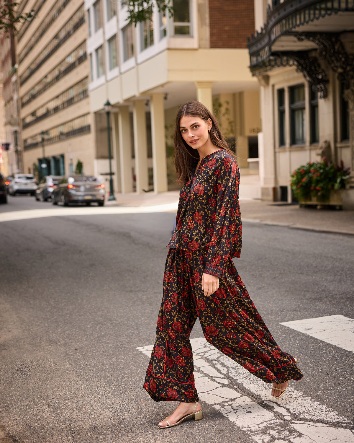 Side view of a person wearing a garnet floral blouse and matching wide-leg pants.