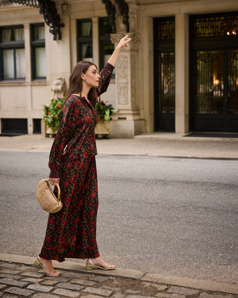 Model wearing the Midwinter Bloom Sasha pants with a matching floral blouse on a city sidewalk.