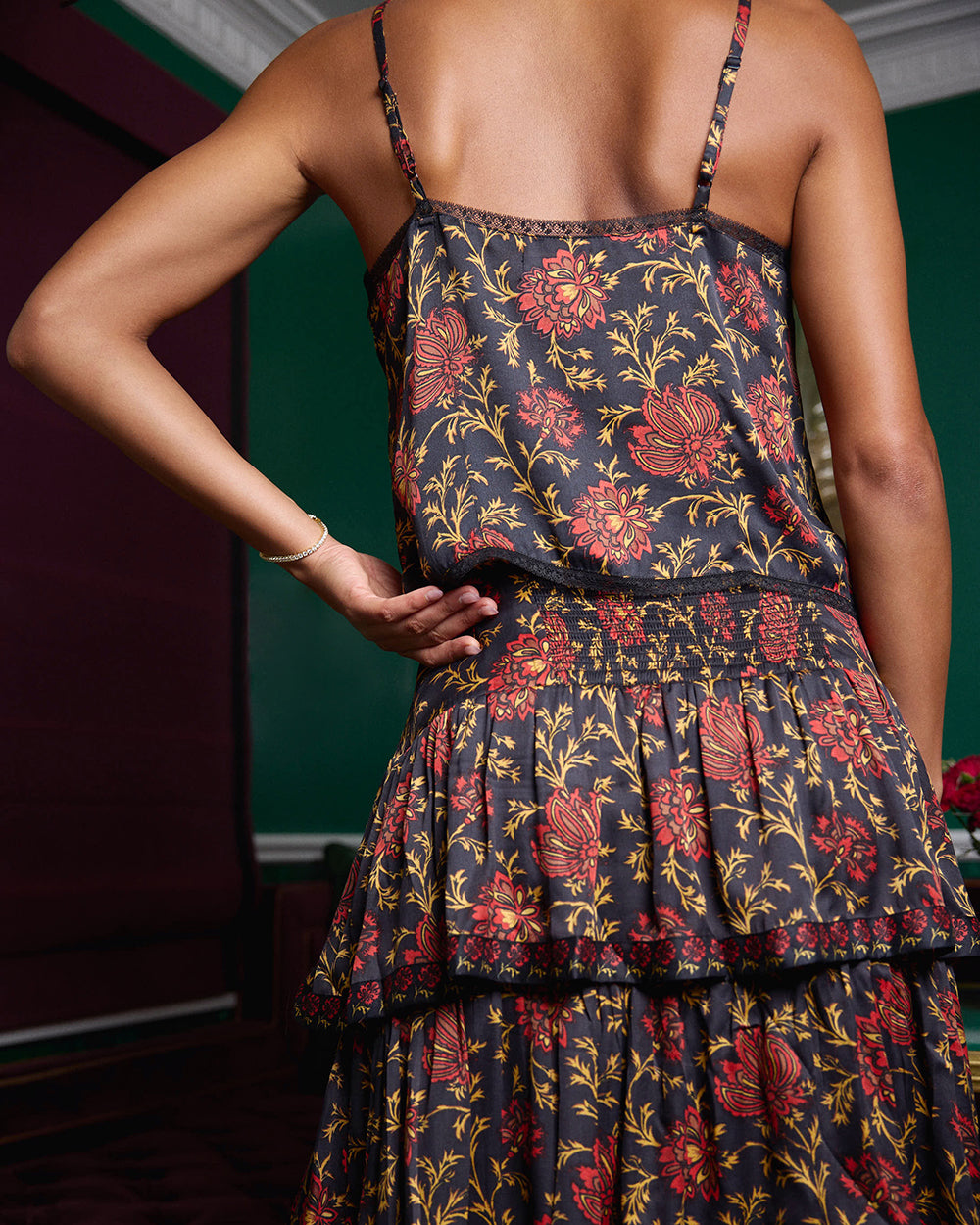 Back view of the Noelle Set showing camisole straps, a gathered waistband, and a tiered floral-print skirt.