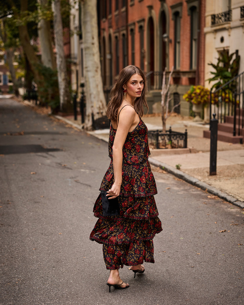 Model wearing the Midwinter Bloom Noelle set with a dark floral print on a residential street.