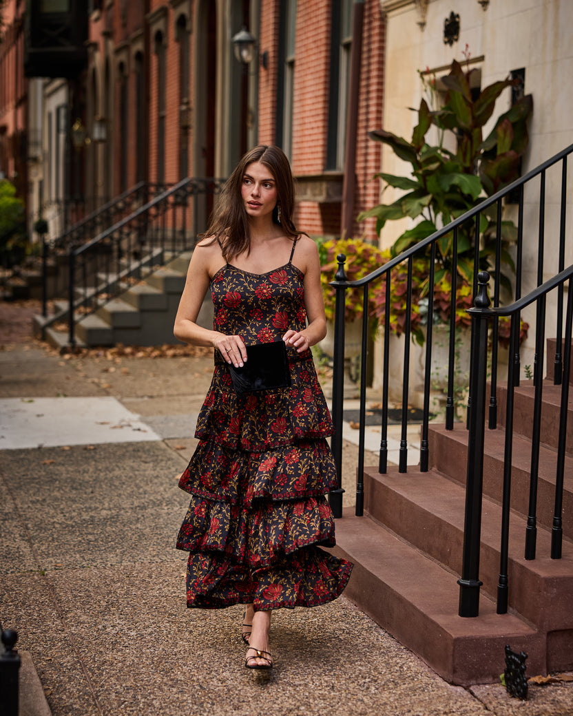 Person wearing the Noelle Set, a floral-print camisole and tiered maxi skirt, outdoors.