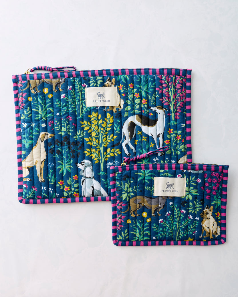 Two indigo Must Love Dogs flat pouches with pink striped trim, showing dog and botanical illustrations.