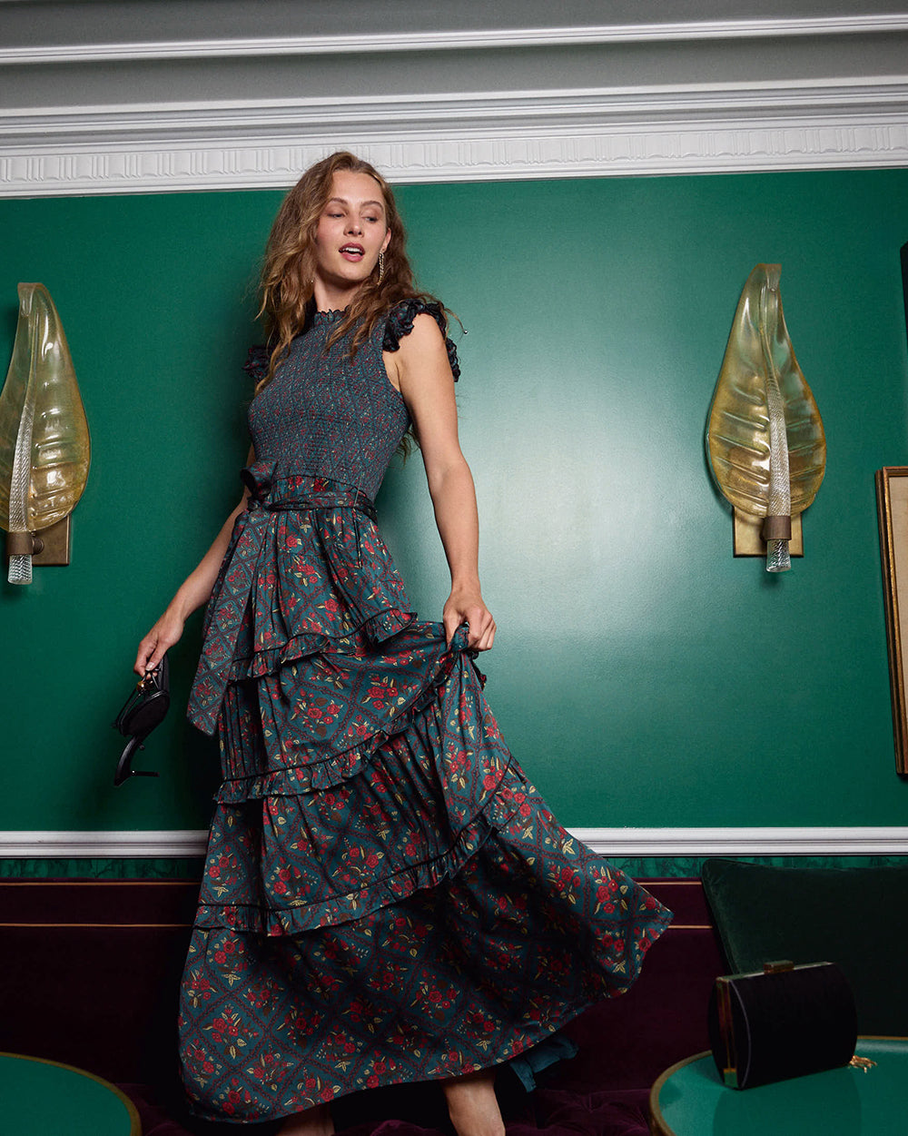 Person lifting the skirt of the Nordic Garden tiered maxi dress to show its ruffled layers and flowing shape.