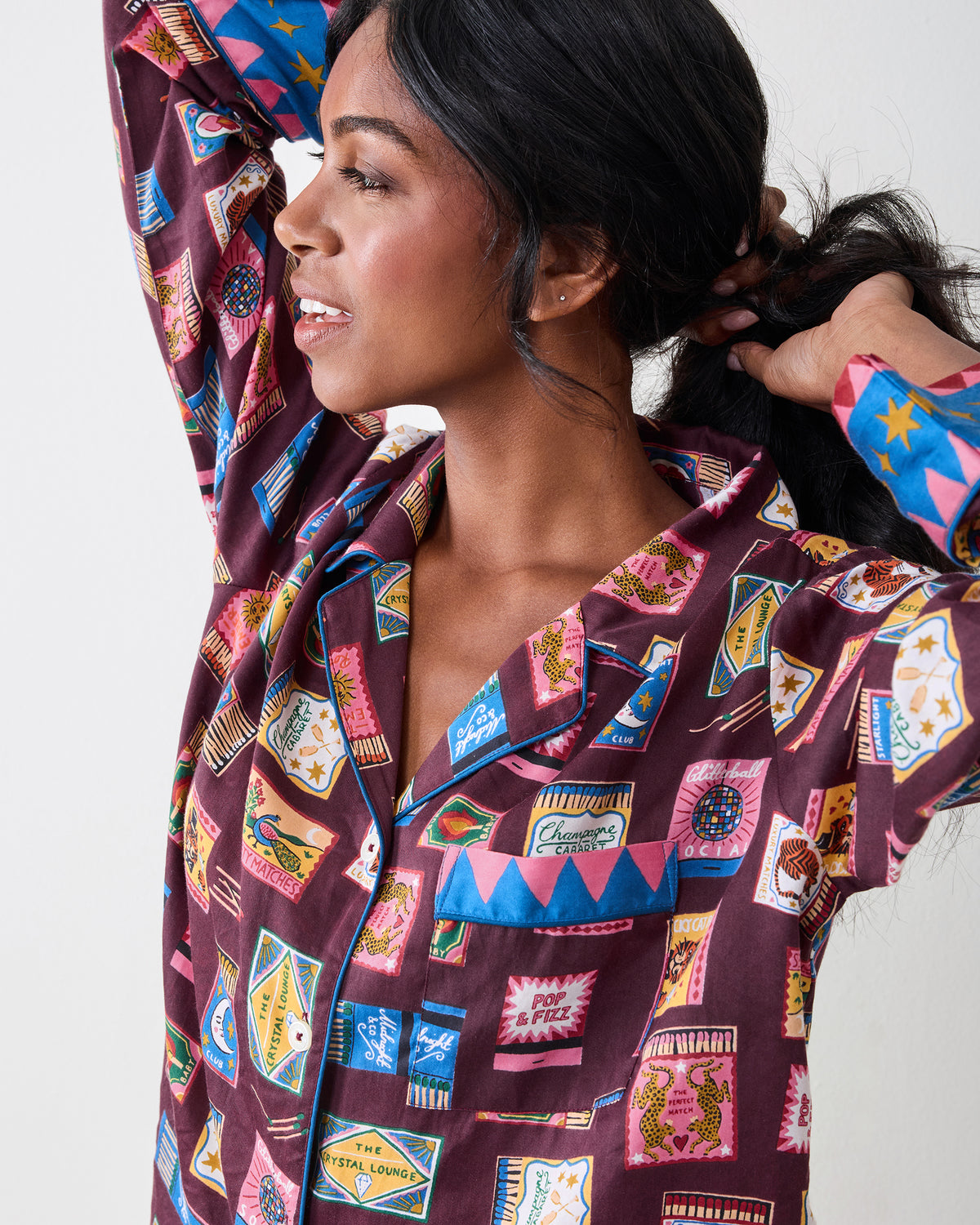 Close-up of the Cabernet Painted Matchbook pajama top showing its multicolored matchbook print, collar, chest pocket, and contrasting cuff.