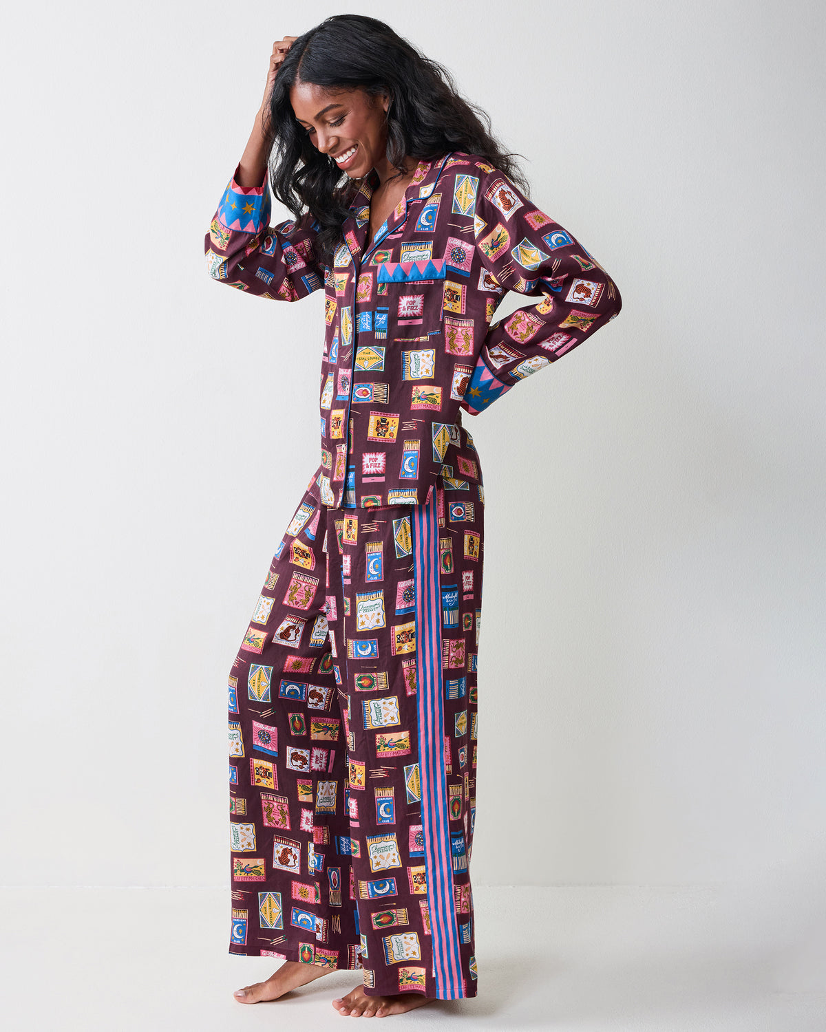 Full-length side view of the Cabernet Painted Matchbook pajama set with a button-front top, wide-leg pants, contrasting cuffs, and side stripes.