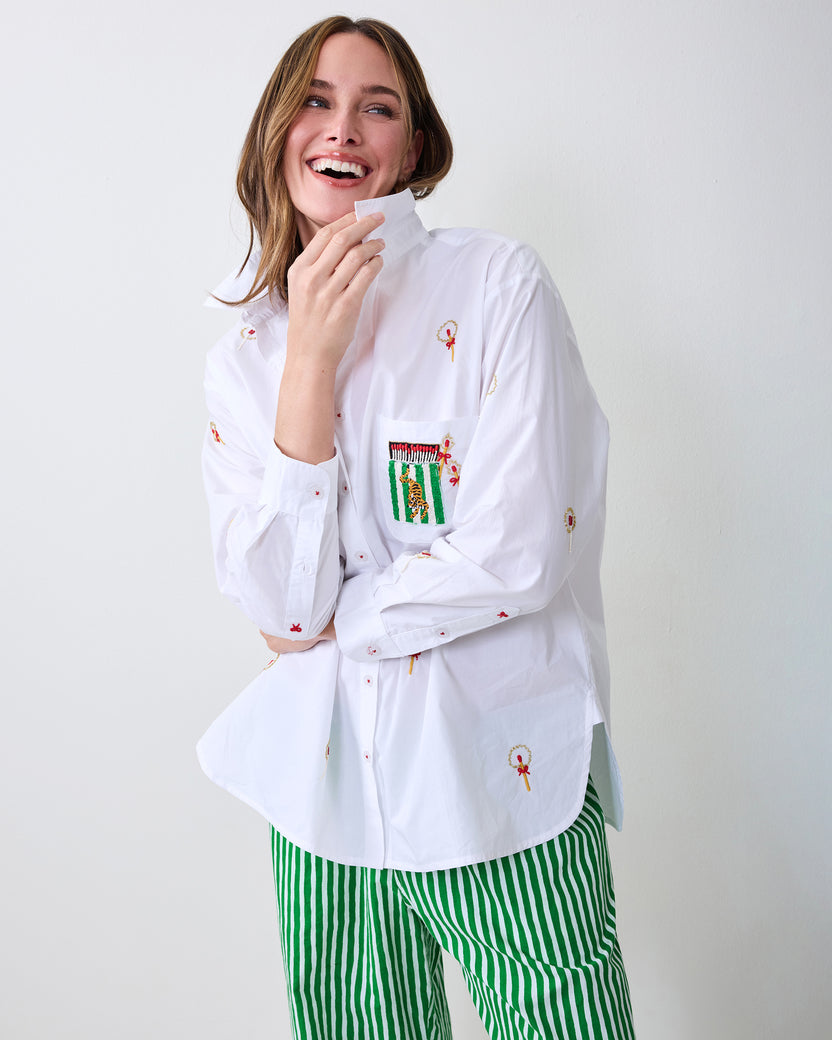Model wearing a white embroidered button-down shirt with green-and-white striped pajama pants.
