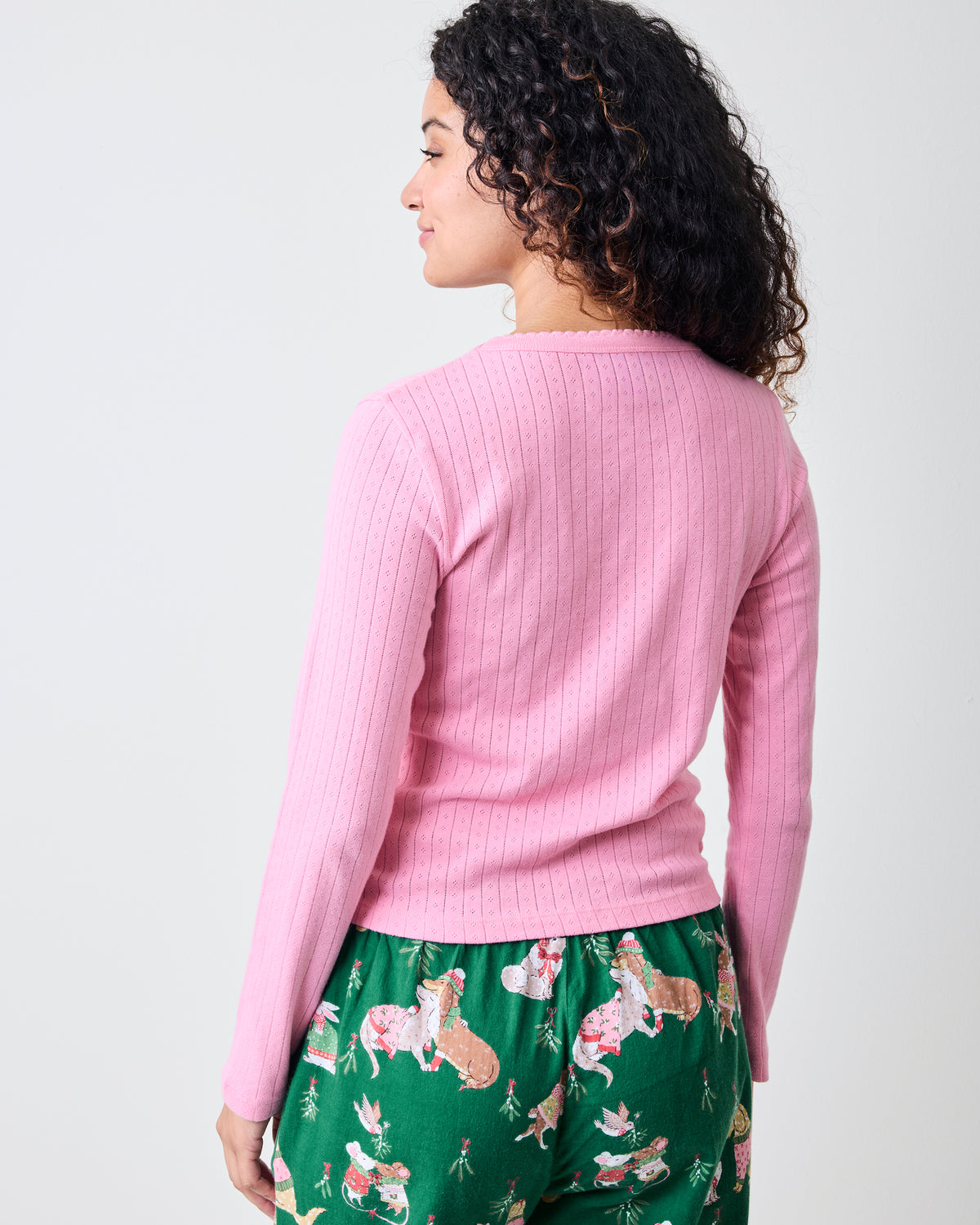 Back view of the pink taffy long-sleeve pointelle top with green patterned pajama pants.
