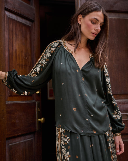 Spruce Hallie blouse with a dark green base, floral tapestry trim on the collar and sleeves, and long gathered sleeves.