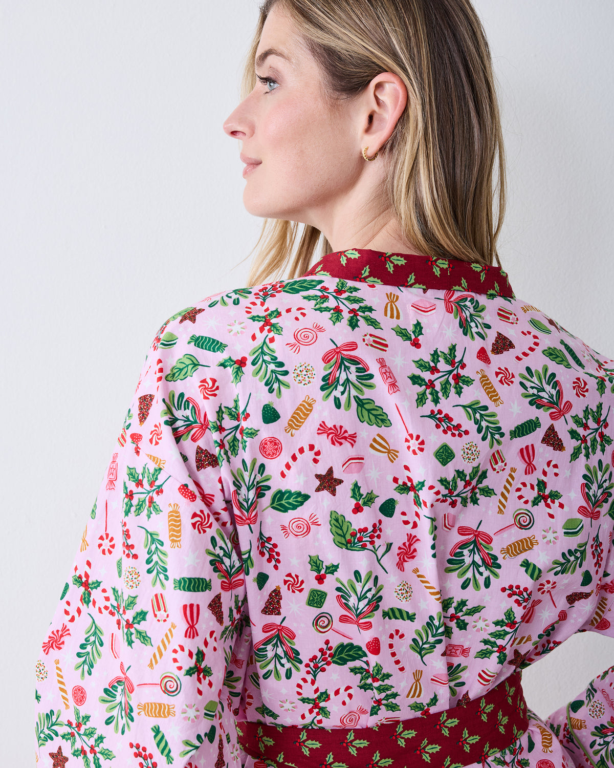 Close back detail of the Sweet Tooth Getting Ready Robe in Candy Pink, showing the holiday print, red collar trim, and waist belt.
