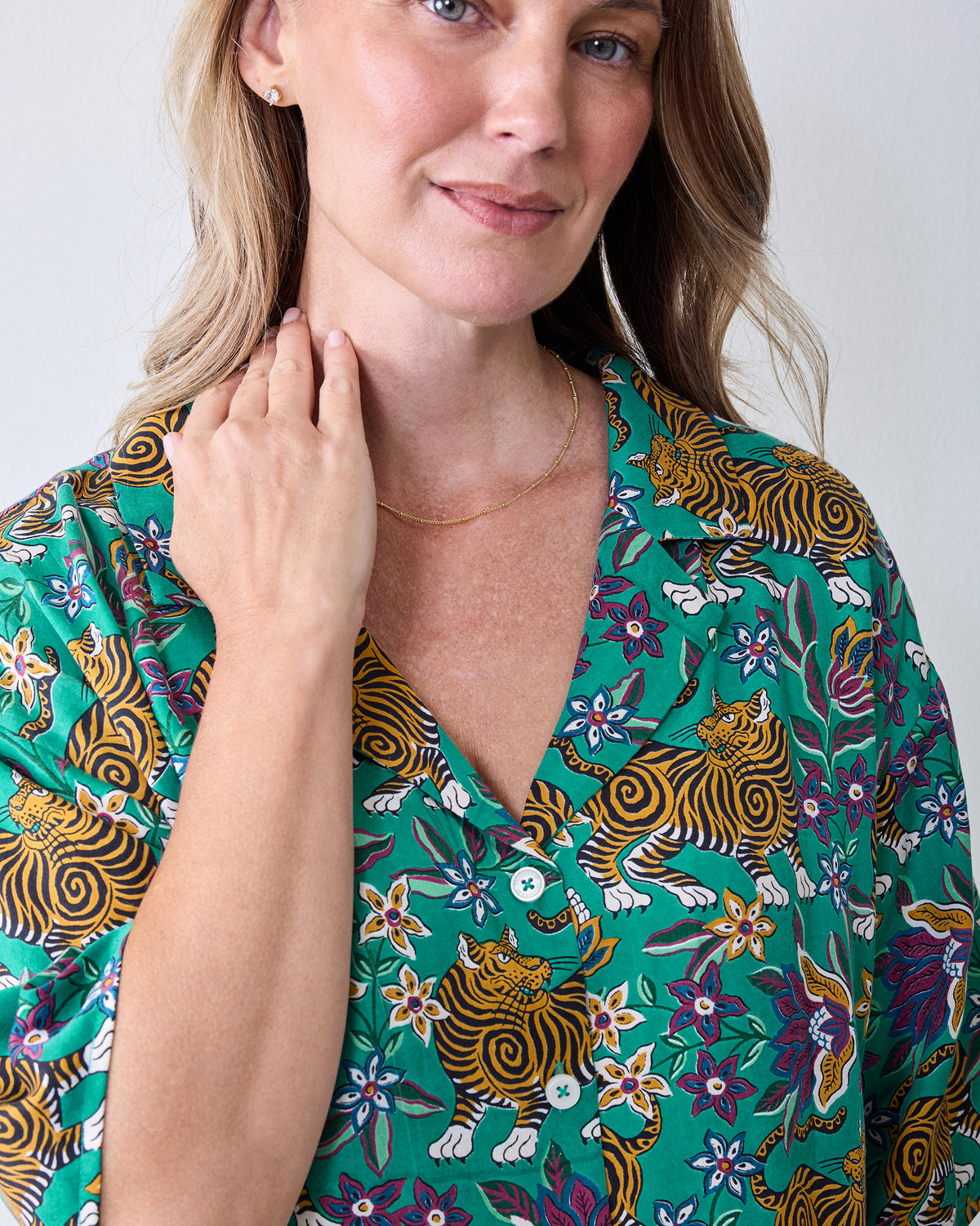 Close-up of the Royal Teal Wildest Dreams shirt showing its notched collar, white buttons, and tiger-and-floral print.