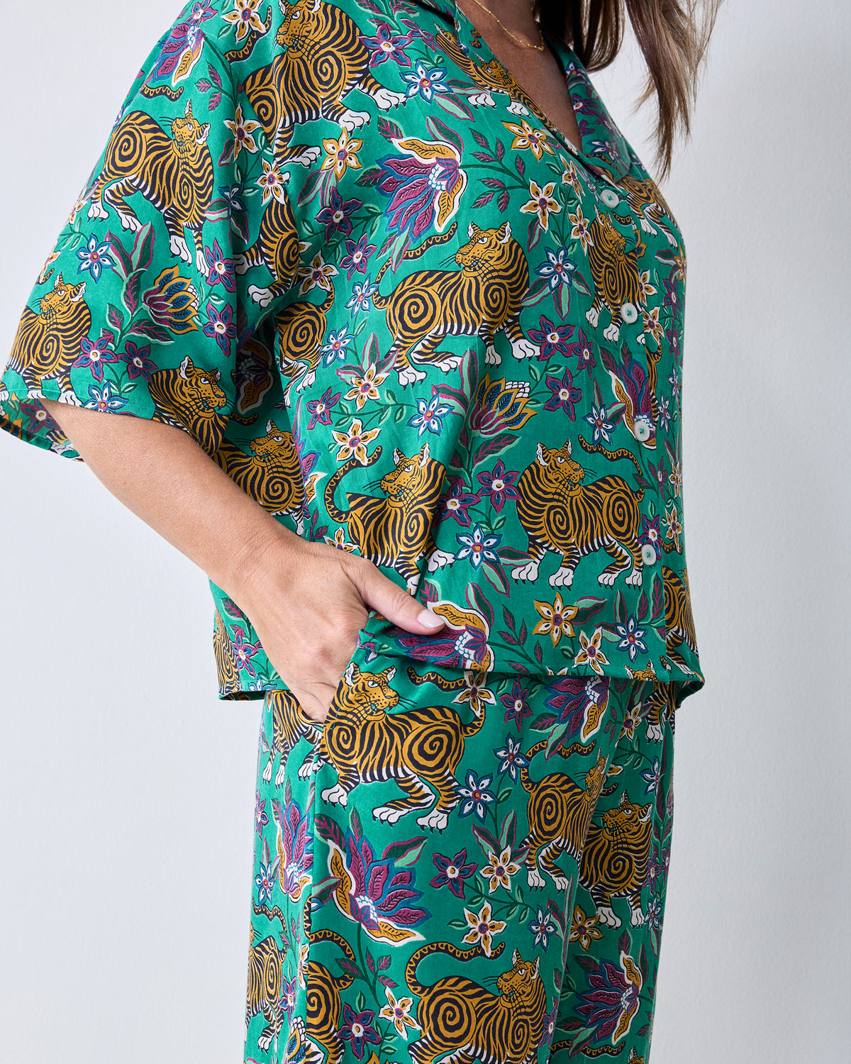 Close-up of the Royal Teal Wildest Dreams shirt and pants showing the button-front shirt, side pocket, and tiger-and-floral print.