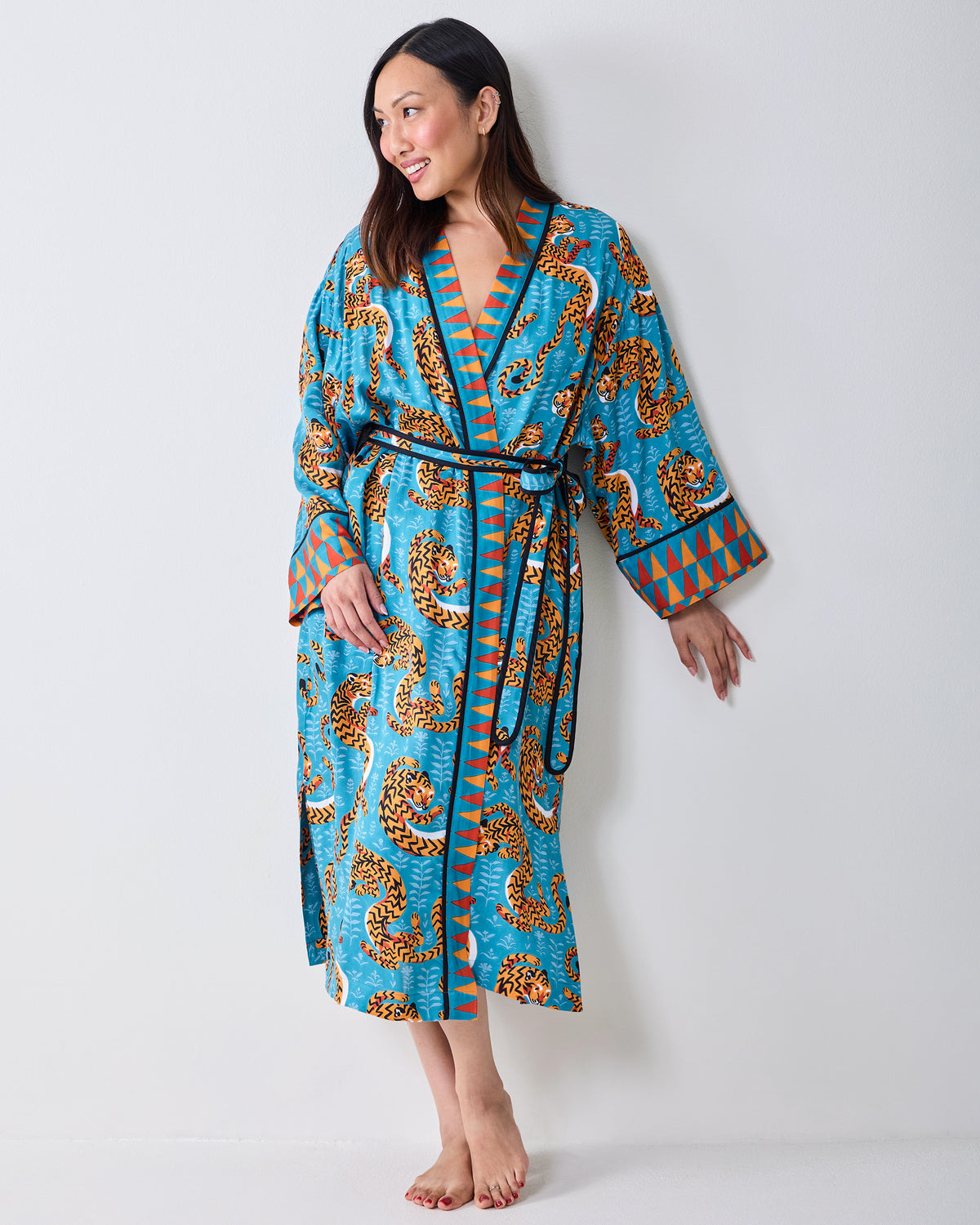 Full-length front view of a model wearing a turquoise tiger-print robe with a waist tie.