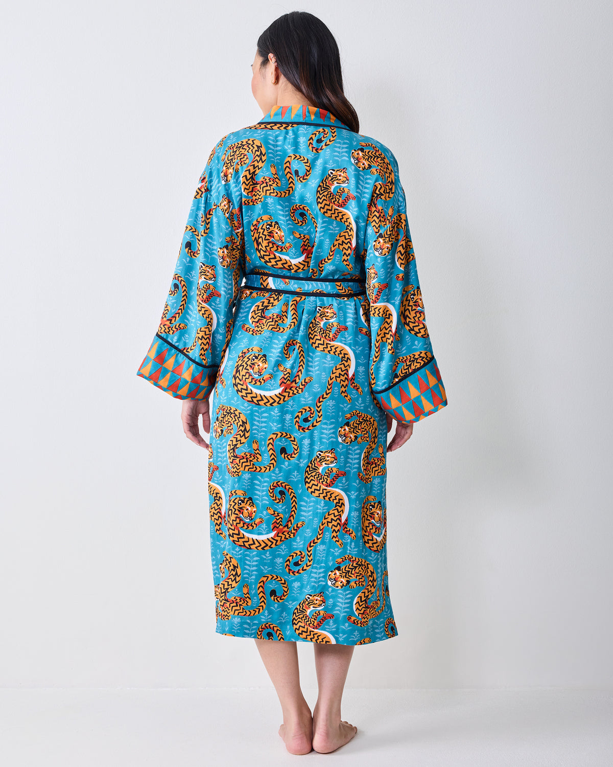 Back view of a turquoise tiger-print robe with a waist tie and geometric cuff trim.