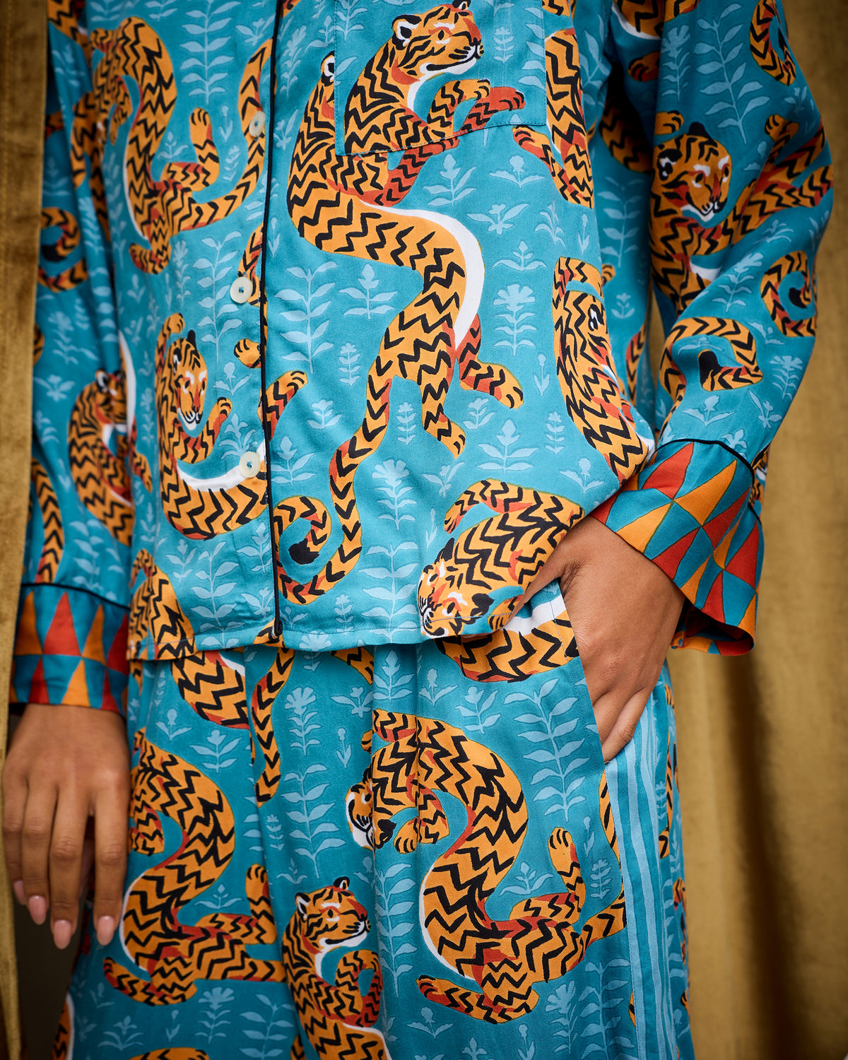 Close view of the Persian Turquoise Twisted Tiger pajama set showing the button-front top, pocket, tiger print, and contrasting cuff.