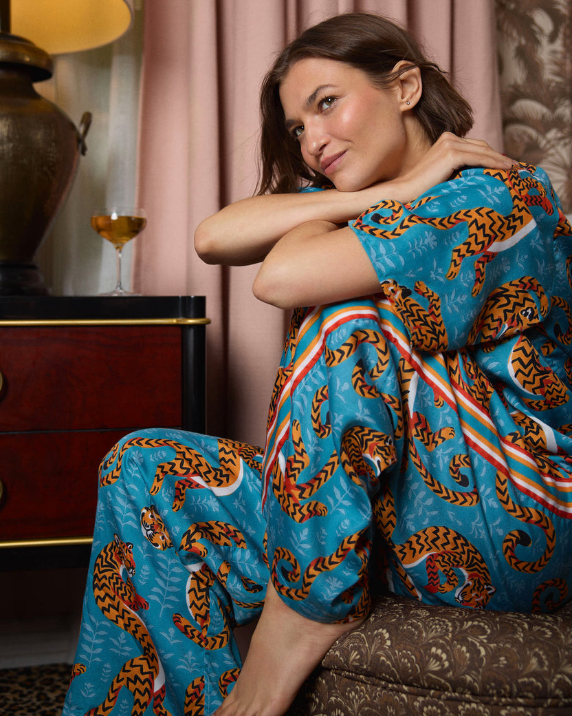 Close view of a model wearing a turquoise tiger-print pajama top and pants.