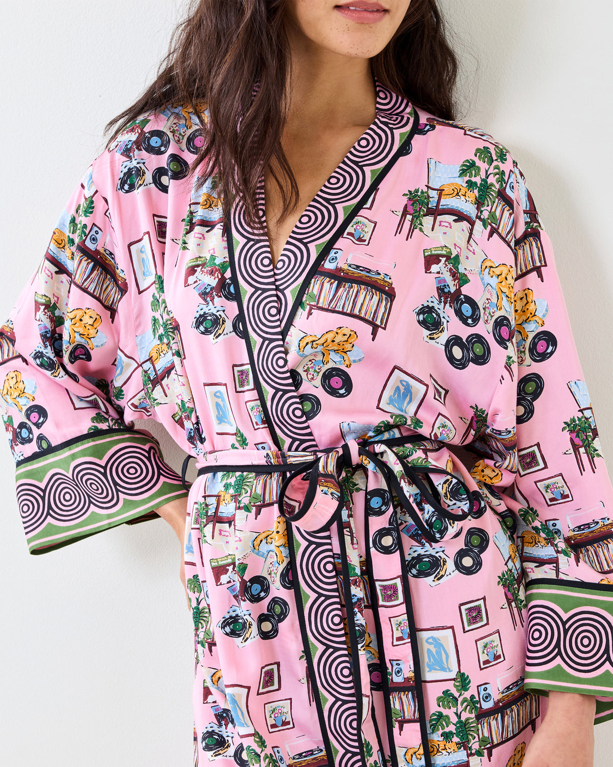Front detail of the pink Vinyl Collector satin robe with a belted wrap front, record-player print, and contrasting circular trim.