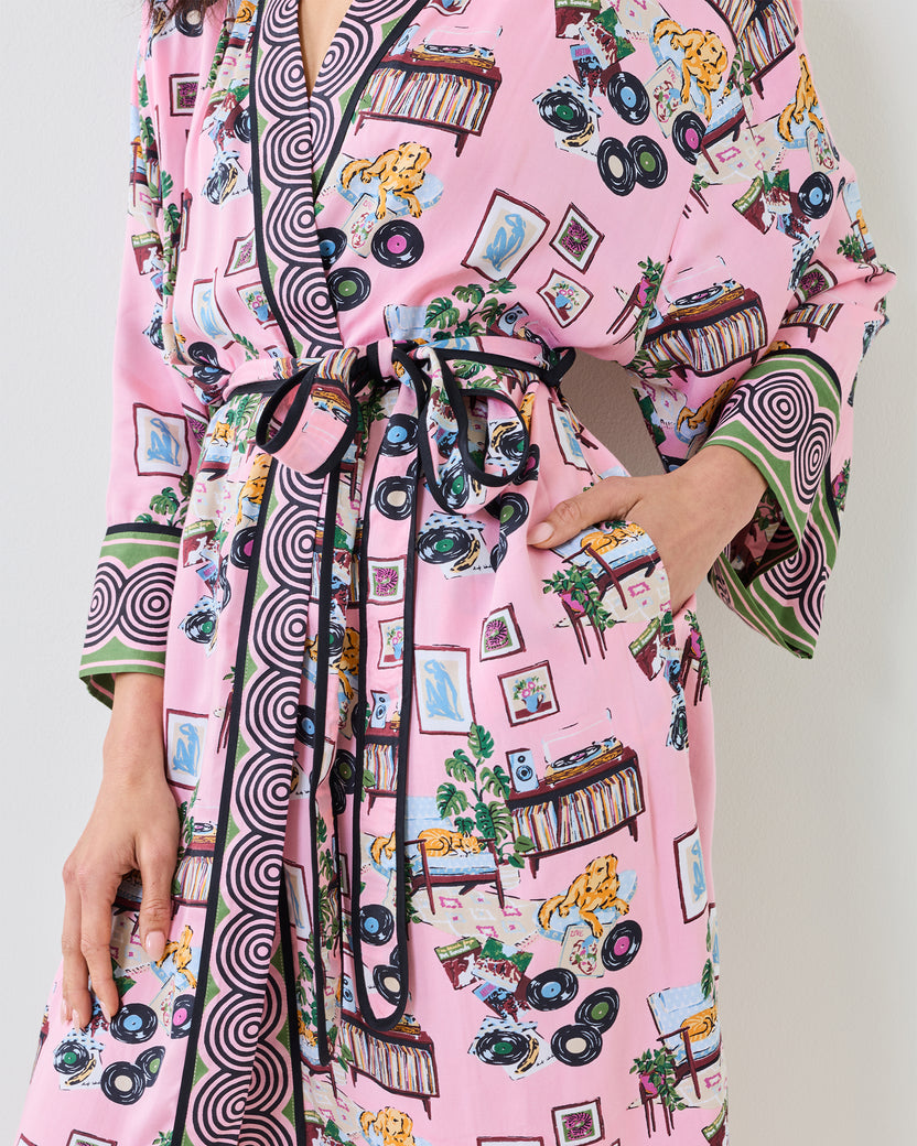Front detail of the pink Vinyl Collector satin robe showing the tie belt, pockets, record-player print, and contrasting cuff trim.
