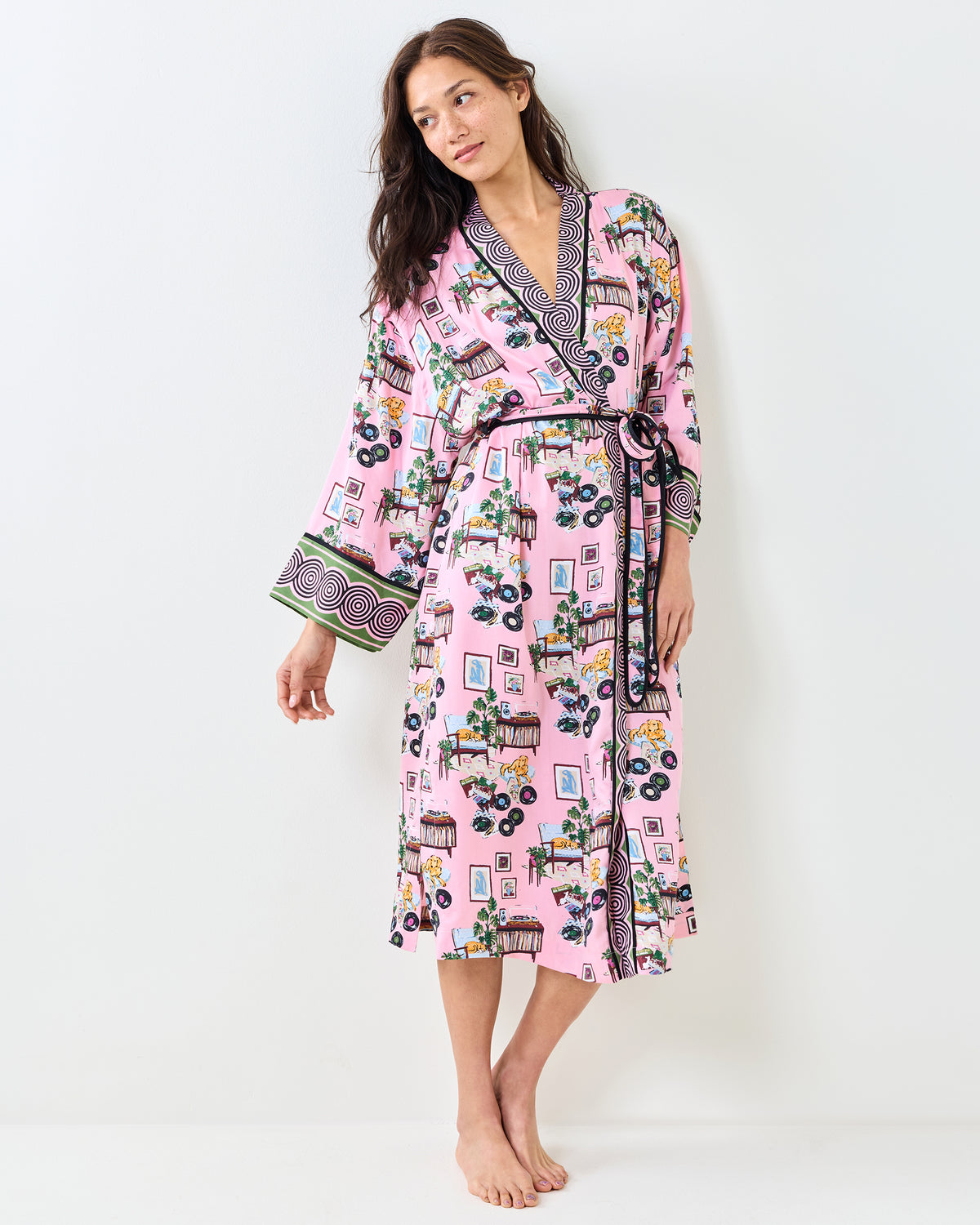 Person wearing the pink Vinyl Collector robe with a black-and-white patterned collar, cuffs, and matching belt.