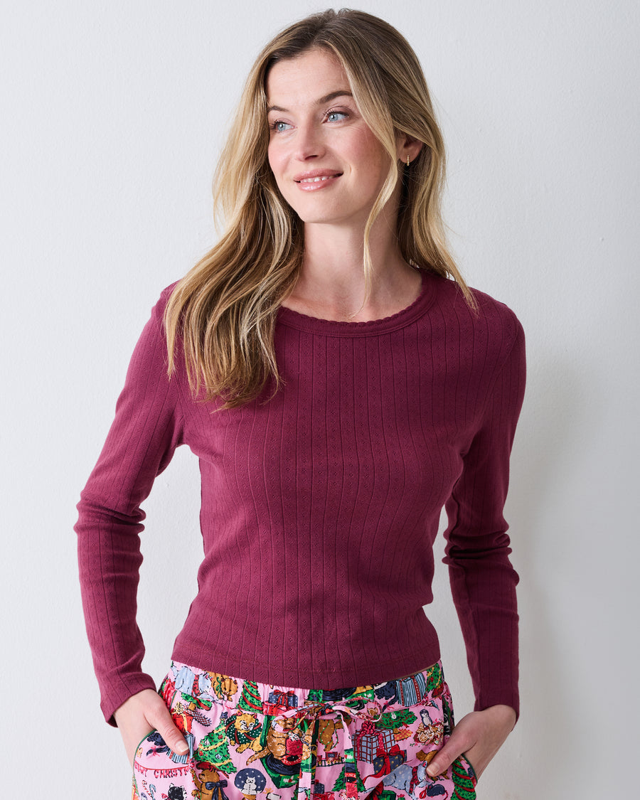 Front view of a wine-colored long-sleeve pointelle top with a scalloped neckline and vertical eyelet pattern.