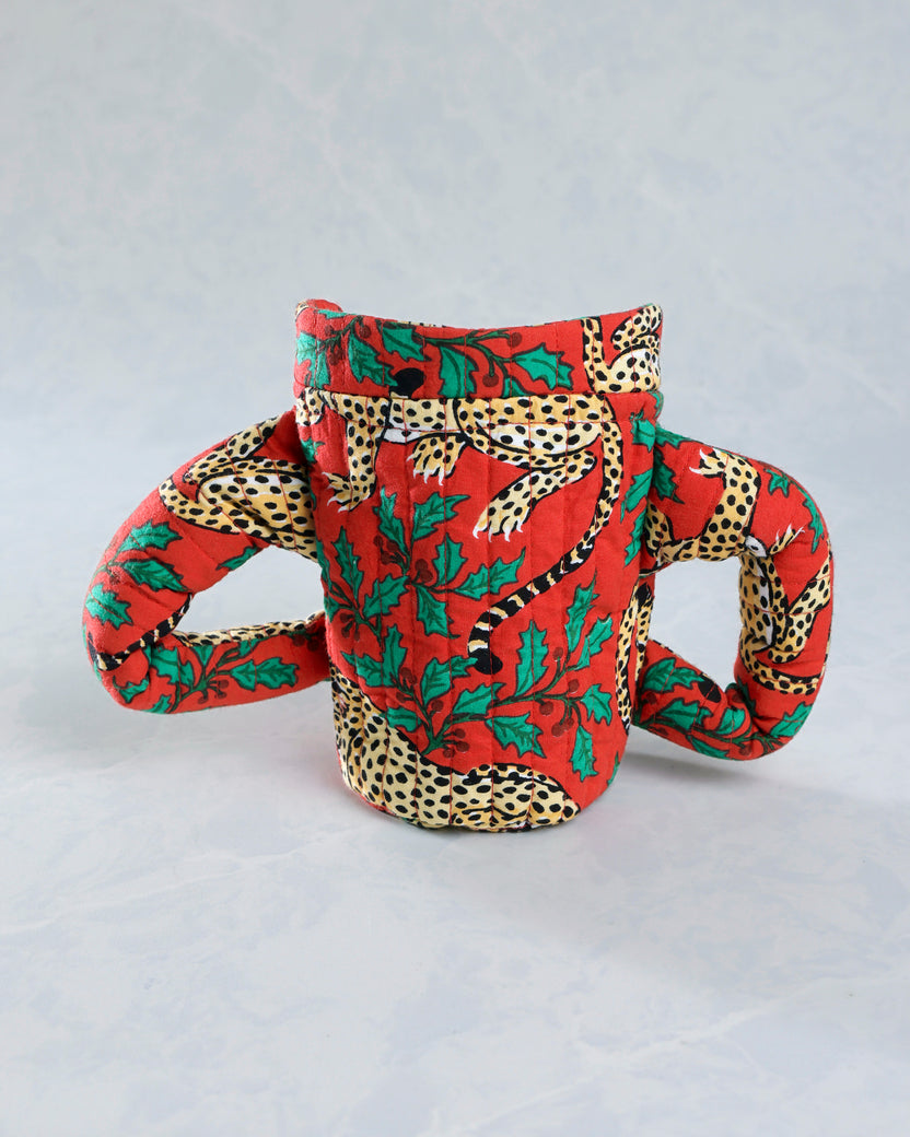 Back view of the Winter Holly Bagheera quilted pajama cozie, showing its padded body and two side handles.