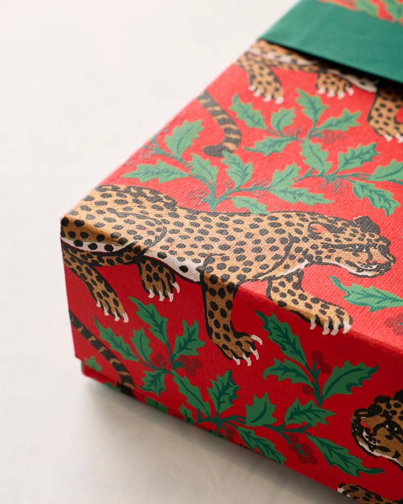 Angled close view of the red Winter Holly Bagheera gift box with leopard-and-holly print