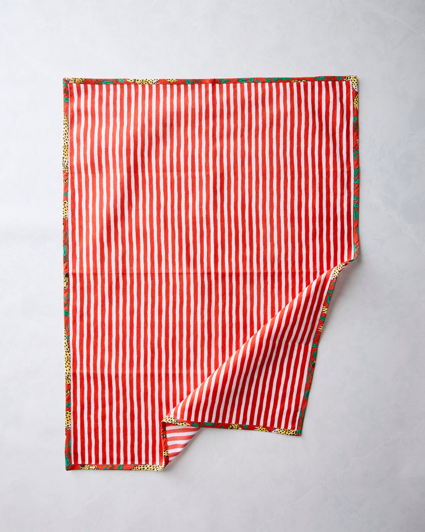 Reverse of a Winter Holly Bagheera tea towel showing red-and-white vertical stripes with the printed design along the edges.