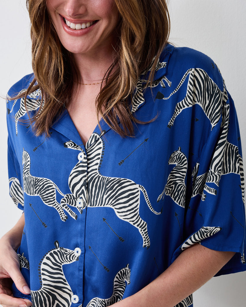 Close-up of the denim-blue zebra-print pajama top showing its collar, buttons, and short sleeves.