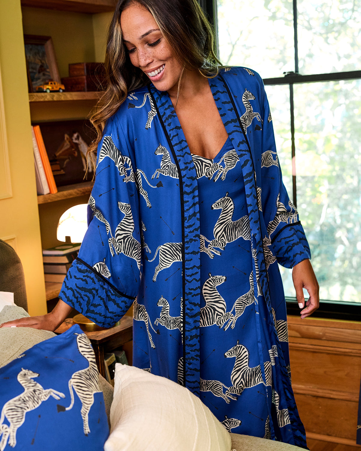 Person wearing a blue zebra-print robe with contrasting patterned trim and cuffs; a matching garment is visible underneath.