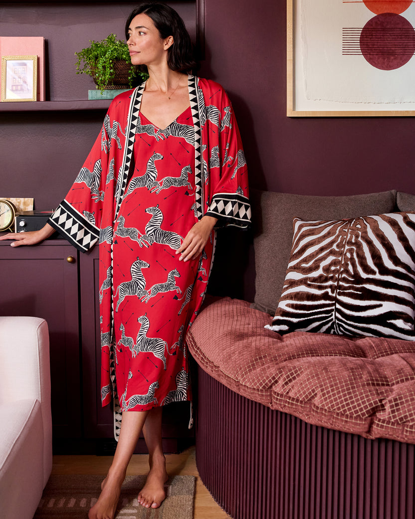 Front view of a person wearing a red zebra-print robe with black-and-white geometric trim over a matching nightie.