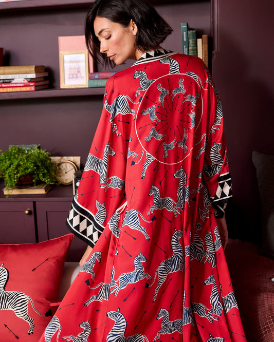 Back view of a red robe with a black-and-white zebra print and geometric sleeve trim.