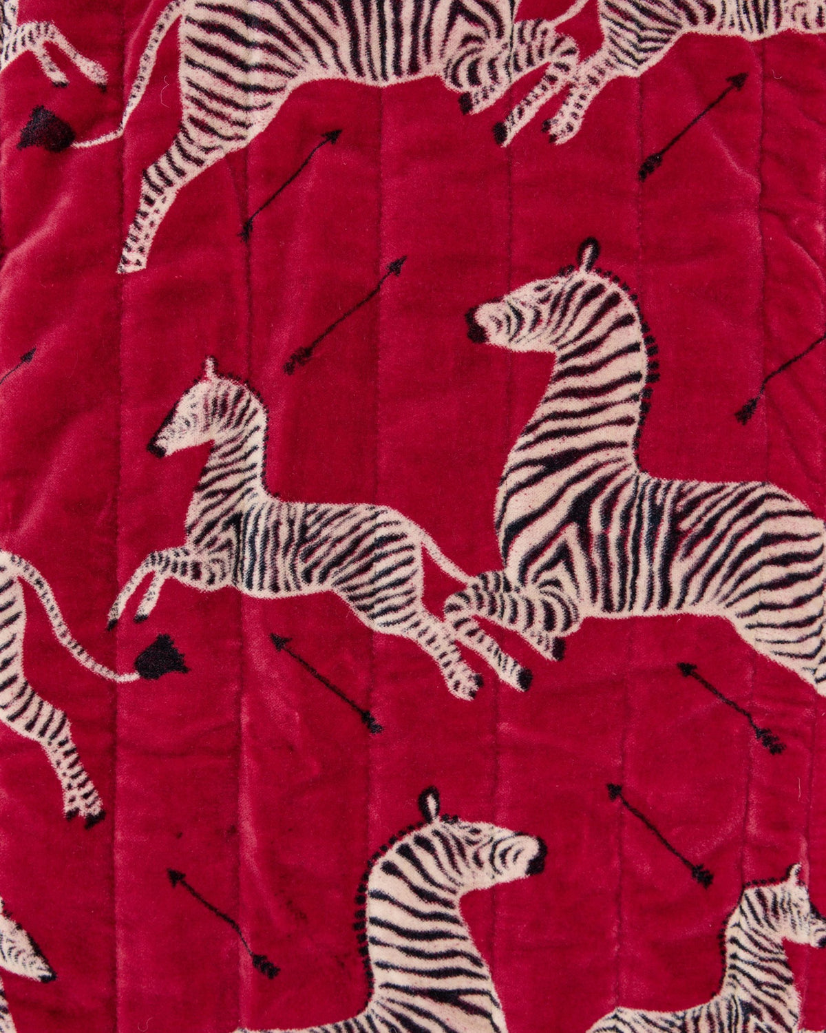 Close-up of the red quilted pouch surface with zebra and arrow prints.